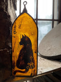 Decorative up cycled orange stained glass panel with a cat silhouette painted on an arched  background