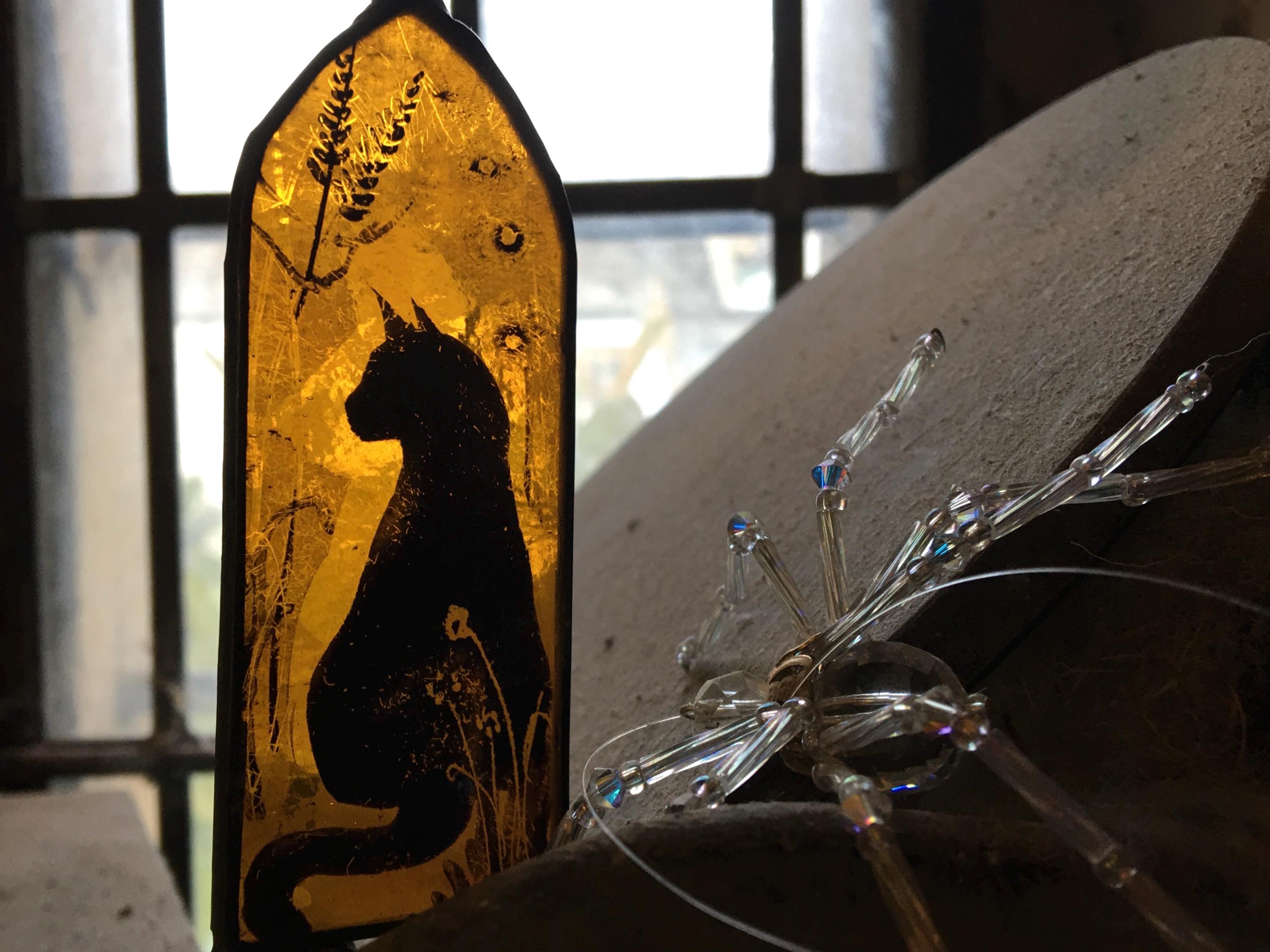 Decorative piece with a silhouette of a cat on an orange background