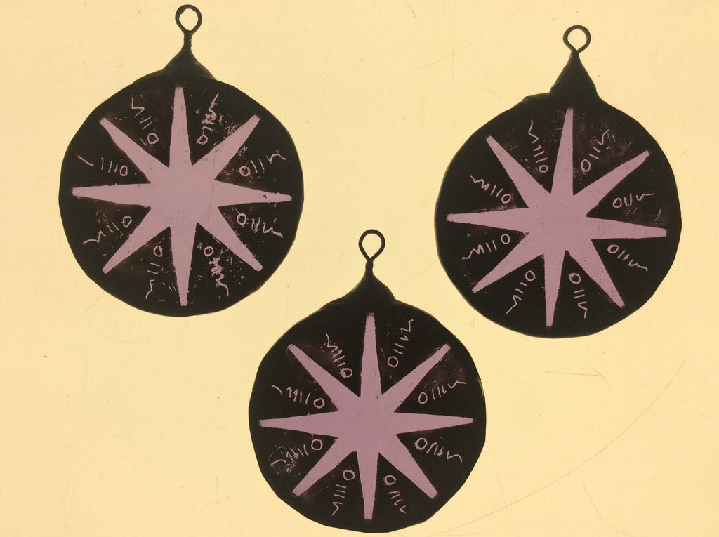 Three completed purple stained glass stars shown on a light box so you can see the detail