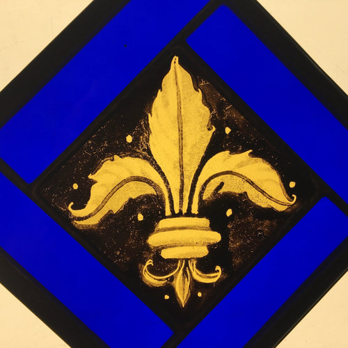 Gold fleur-de-lis stained glass design on a blue and black background